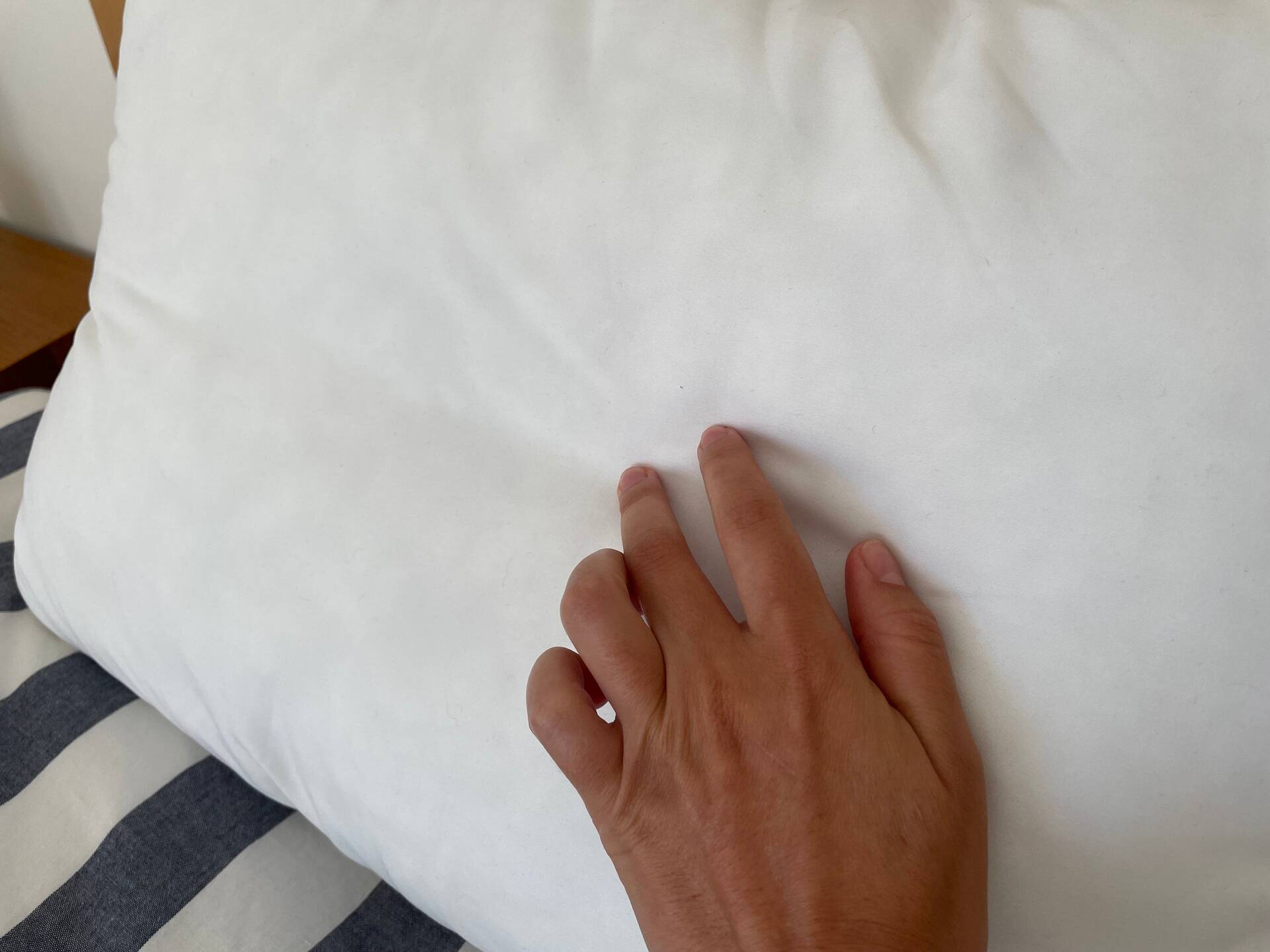 imagem de uma mão encostando na capa do travesseiro emma comfort